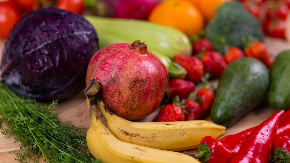 A variety of fresh fruits and vegetables arranged beautifully on a wooden table, showcasing natural nutrition.